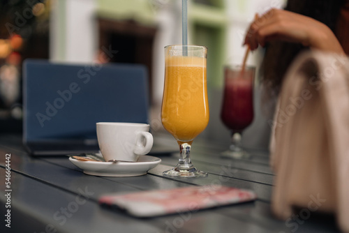 Freshly squeezed orange juice and red juice, with a cup of coffee on the table in the cafe.