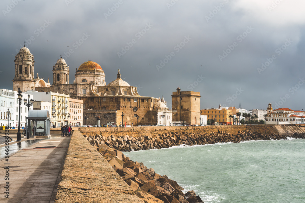 Walking along the Atlantic Ocean towards the Cathedral of Cadiz, Andalusia, Spain