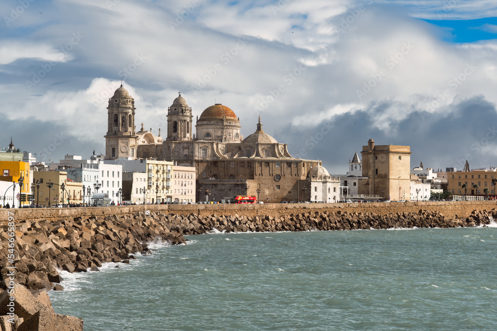 Walking along the Atlantic Ocean towards the Cathedral of Cadiz, Andalusia, Spain