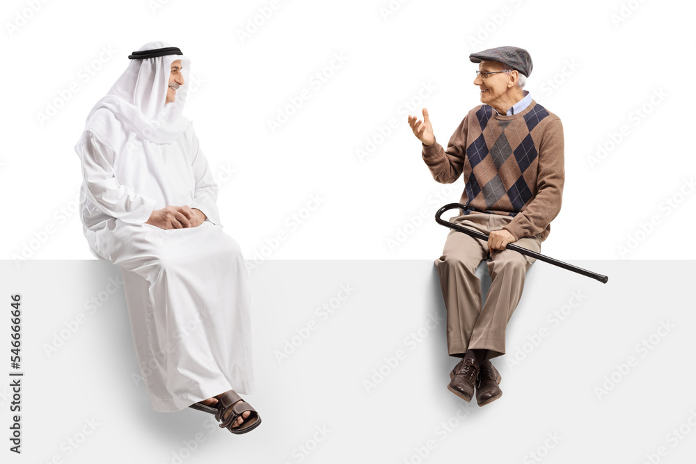 Stockfoto med beskrivningen Arab man in an ethnic robe sitting on a blank  panel with an elderly man and talking | Adobe Stock