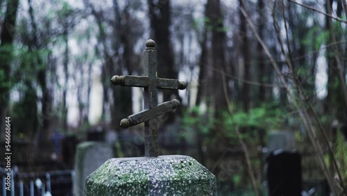 Religious cross in cemetery. Spooky cemetery landscape with old tombstones