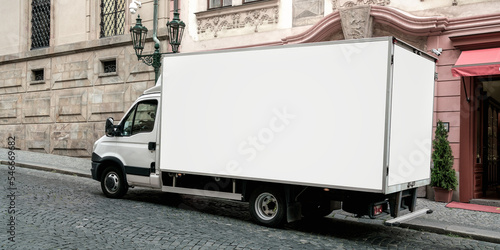 Delivery cargo truck with blank white board for mockup information is parked at urban street