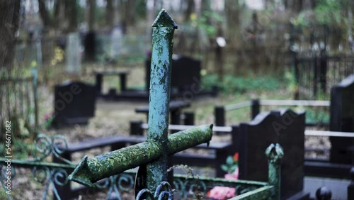 Religious cross in cemetery. Spooky cemetery landscape with old tombstones