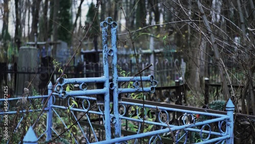Religious cross in cemetery. Spooky cemetery landscape with old tombstones