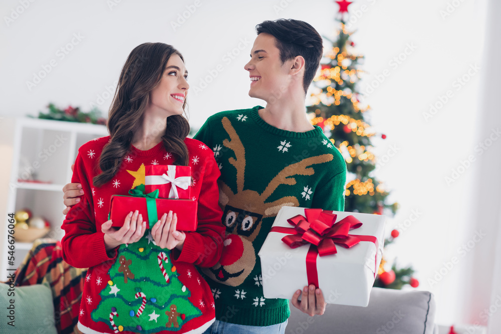 Obraz premium Portrait of attractive pretty couple sharing gifts xmas morning good mood enjoying time together room house indoors