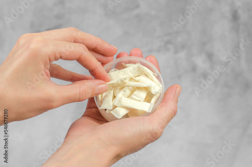 Woman's hand takes Swedish snus from a box, close-up