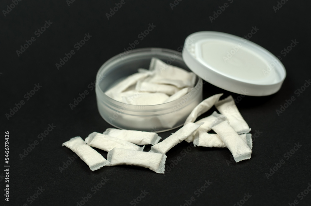 Swedish snus sachets. Open box with snus on a black background. Swedish snus sachets. Open box with snus on a black background.