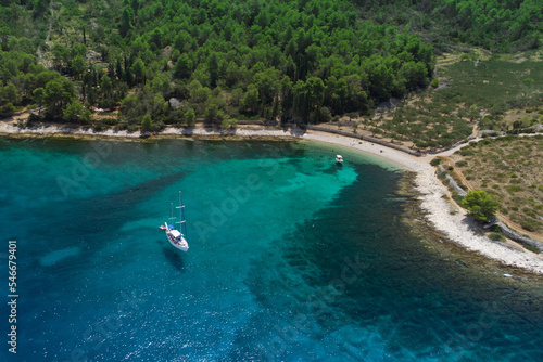 Turquoise beach in Dalmatia with boats anchored off shore