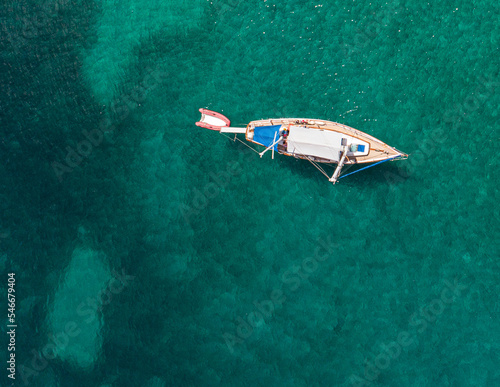 A boat with a blue canopy anchored in a Dalmatian cove