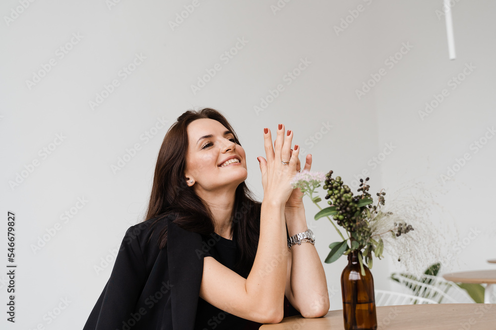 Cheerful girl is making wishes and enjoy lifestyle in white office. Young business woman is smiling in cafe. Cheerful girl is making wishes and enjoy lifestyle in white office. Young business woman is smiling in cafe.