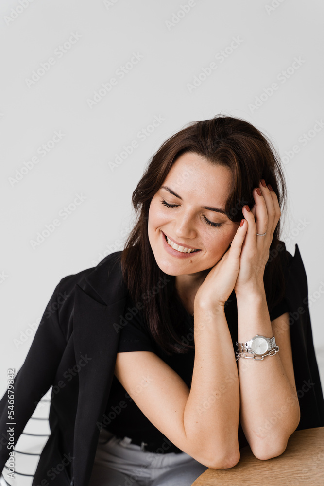 Cheerful girl with closed eyes is making wishes and enjoy lifestyle in white office. Young business woman is smiling in cafe. Cheerful girl with closed eyes is making wishes and enjoy lifestyle in white office. Young business woman is smiling in cafe.