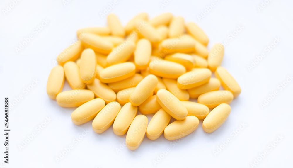 Close-up texture of yellow multivitamin tablets on white background. Healthy lifestyle concept Close-up texture of yellow multivitamin tablets on white background. Healthy lifestyle concept