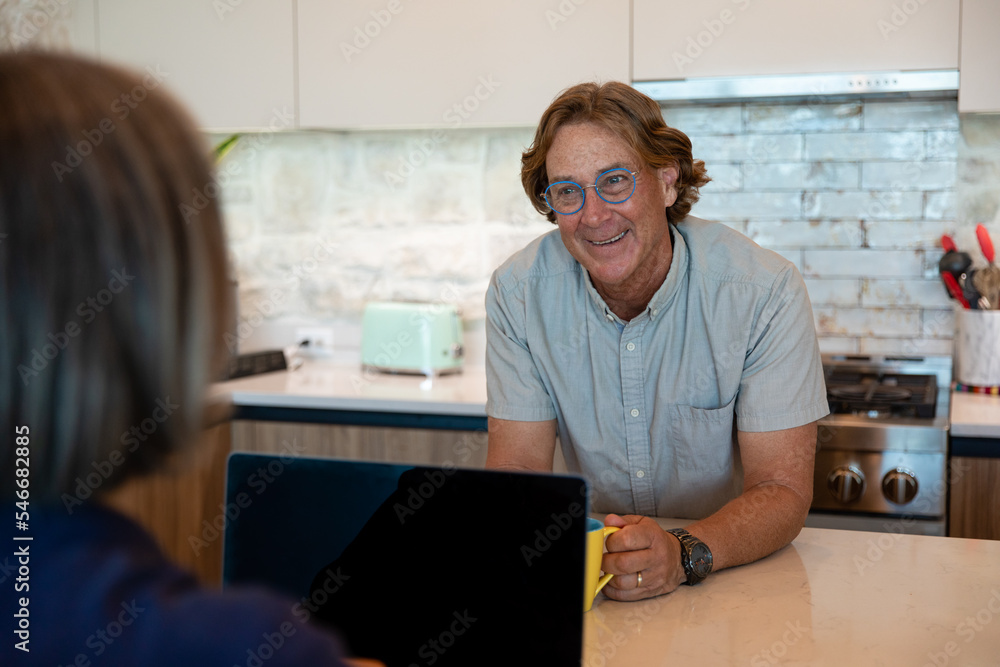 Smiling Man Talks To His Wife While Drinking Coffee Smiling Man Talks To His Wife While Drinking Coffee