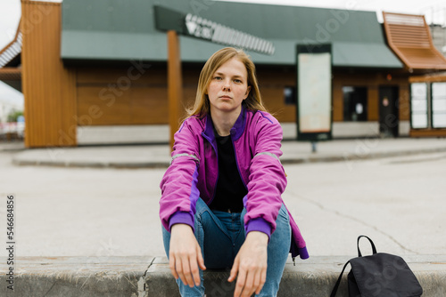 Young  woman in depression sitting outdoors .