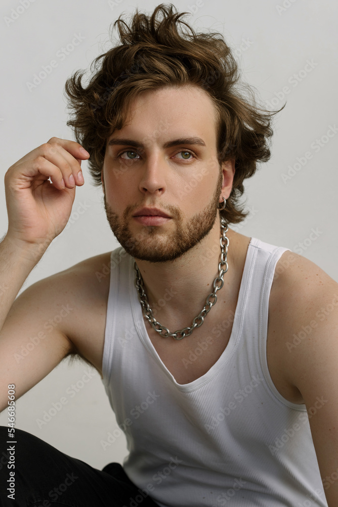 Attractive bearded guy with messy hair in a white shirt and chain Attractive bearded guy with messy hair in a white shirt and chain