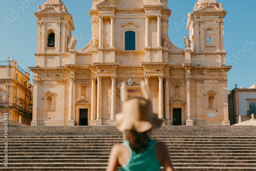 Tourist with hat in front of Palazo Nicolaci in Noto, Sicily. photo