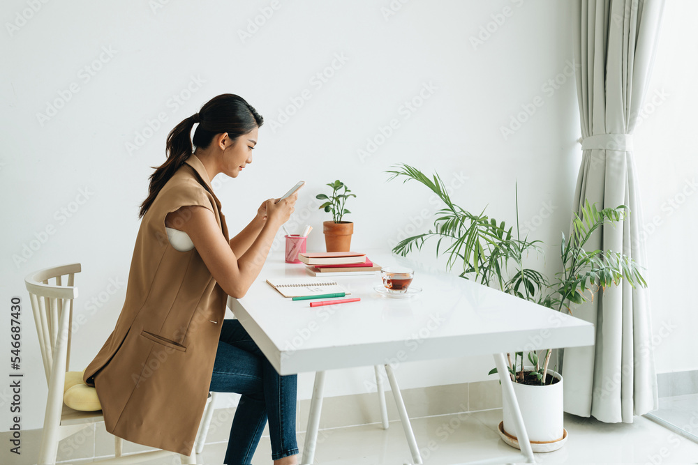 millennial woman with mobile phone making notes preparing to exams millennial woman with mobile phone making notes preparing to exams