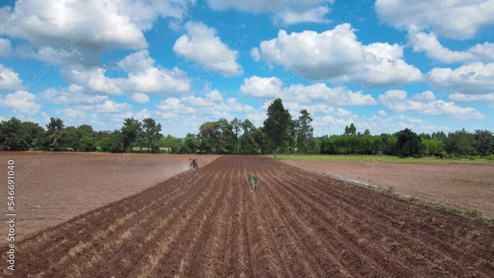 Drone Photography high angle shot, at the cassava plantation. while the tractor was adjusting the soil on a clear sky day in a rural town in Thailand. Drone Photography high angle shot, at the cassava plantation. while the tractor was adjusting the soil on a clear sky day in a rural town in Thailand.