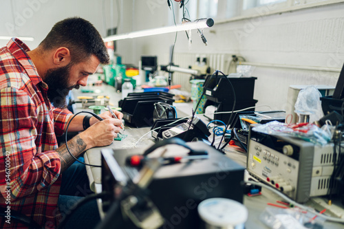 Electronics engineer working in a workshop with tin soldering parts