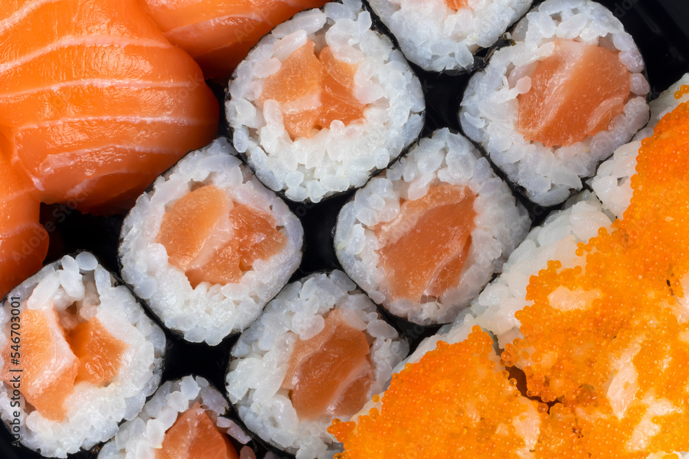 Salmon sushi and sashimi nigiri and maki roll closeup. Delicious japanese food with fresh fish, restaurant delivery set. Salmon sushi and sashimi nigiri and maki roll closeup. Delicious japanese food with fresh fish, restaurant delivery set.