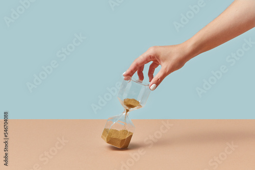 Sandglass with golden sand in female hand. photo