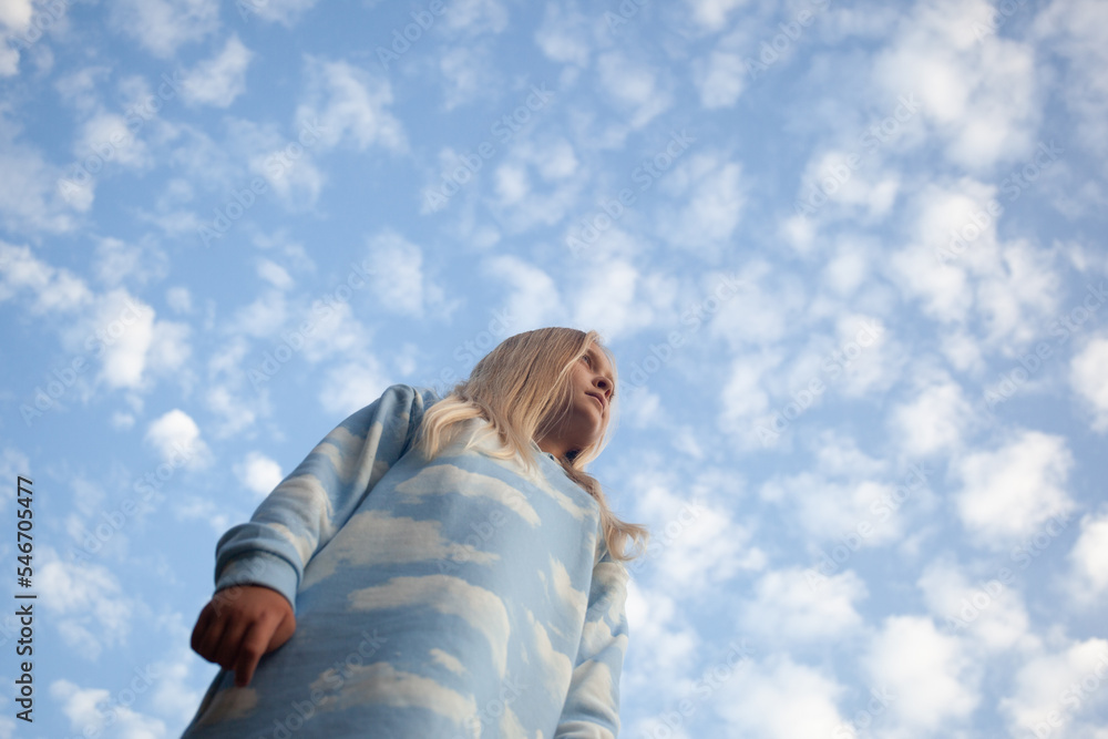 Youth photographed from below looks into big sky. Youth photographed from below looks into big sky.