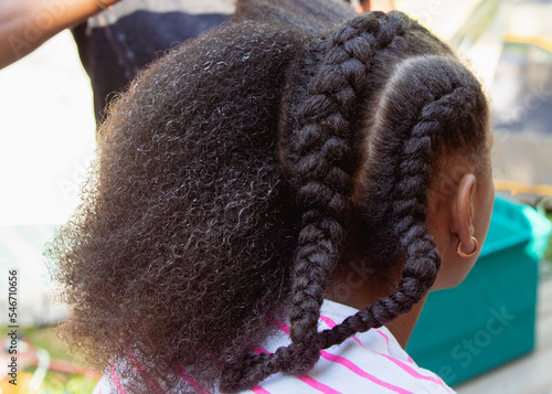 Mother combing her child's kinky curly coily hair