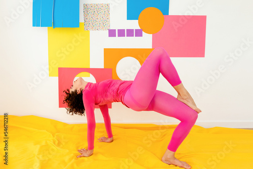 Slim flexible lady exercising on bed in morning photo