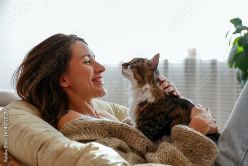 Photography Portrait of young woman holding cute norwegian cat with green eyes