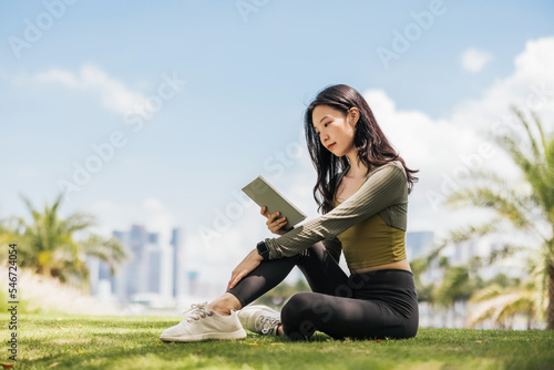 Girl reading e-book in the park photo