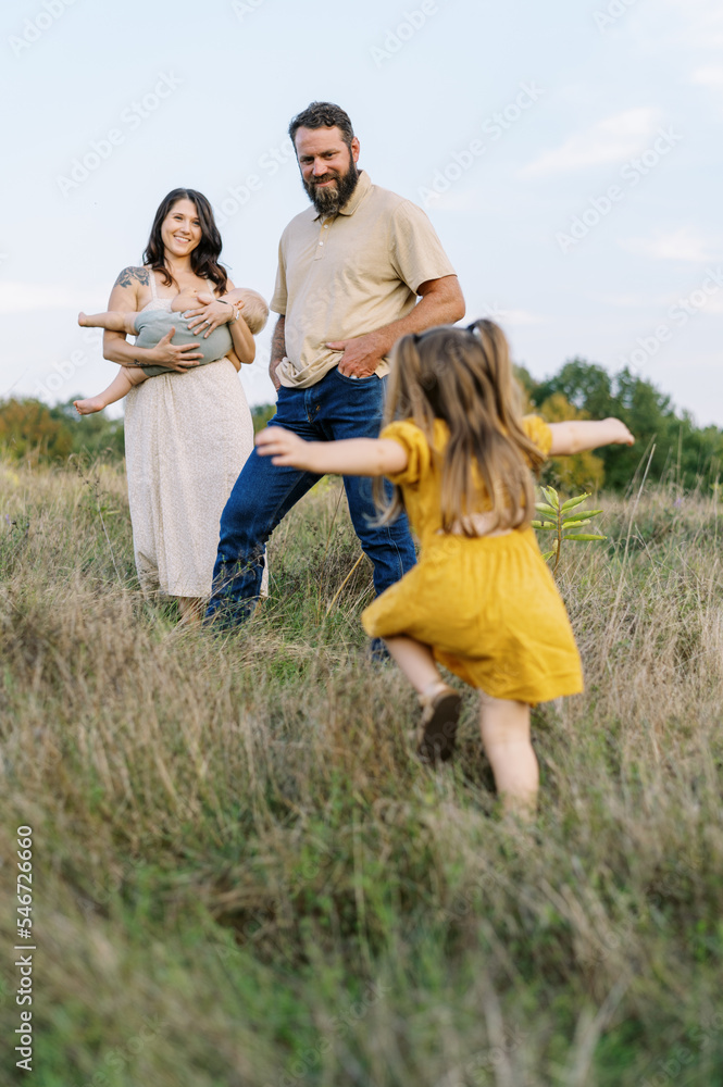 Family in a field of tall grass together outdoors Family in a field of tall grass together outdoors