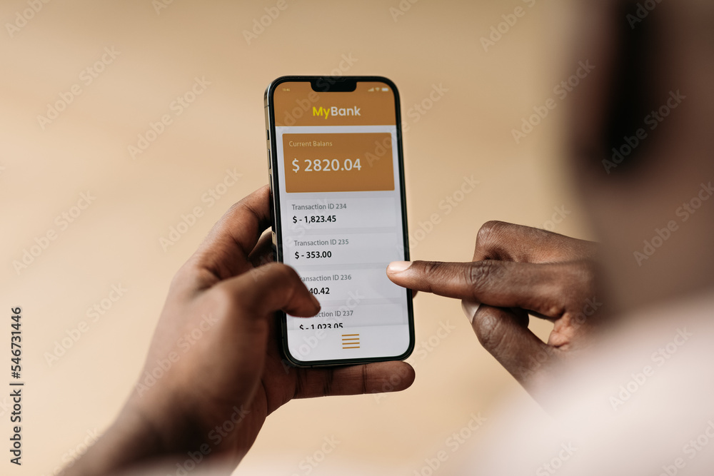 © Studio Firma/Stocksy - Man Checking Bank Account on Phone © Studio Firma/Stocksy - Man Checking Bank Account on Phone