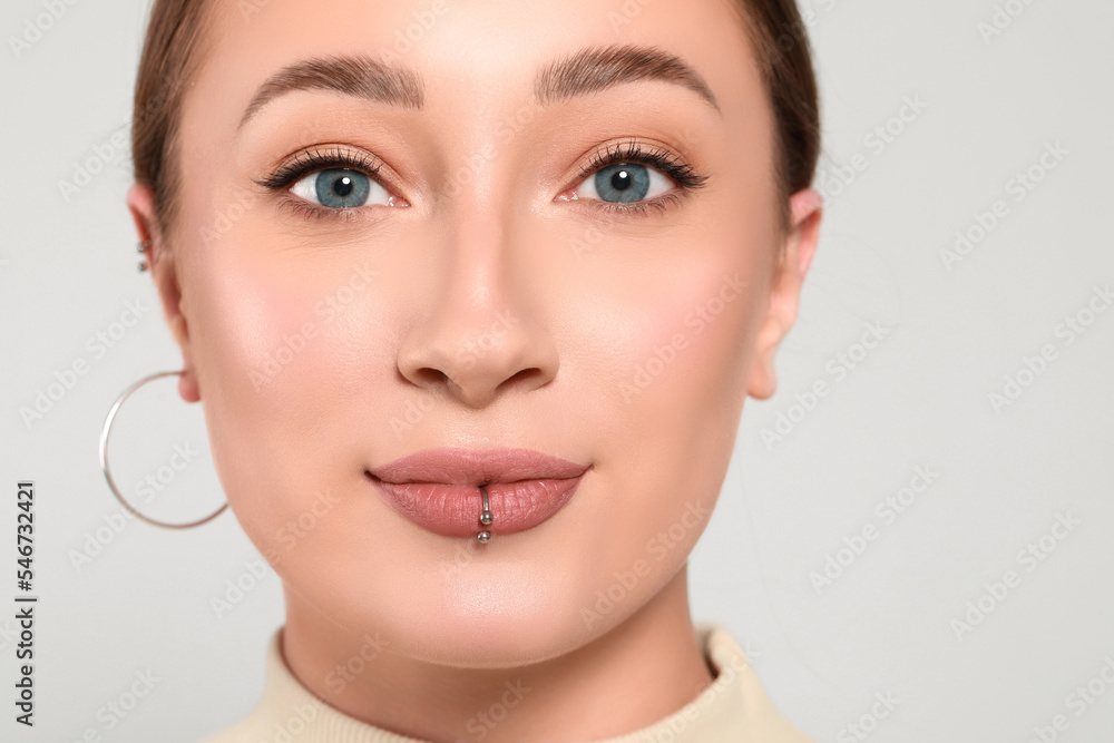 Young woman with lip piercing on white background, closeup Young woman with lip piercing on white background, closeup