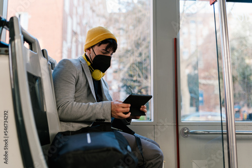 Young man browsing tablet in train wagon photo
