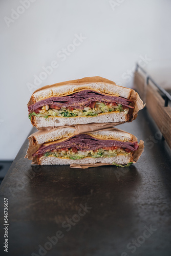 Close up of a pastrami sandwich cut into two photo