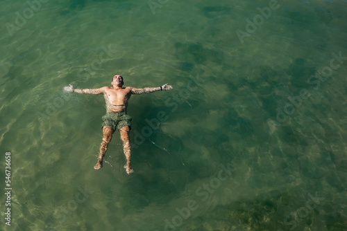 Wallpaper Mural man bathing lying on his back in the sea Torontodigital.ca
