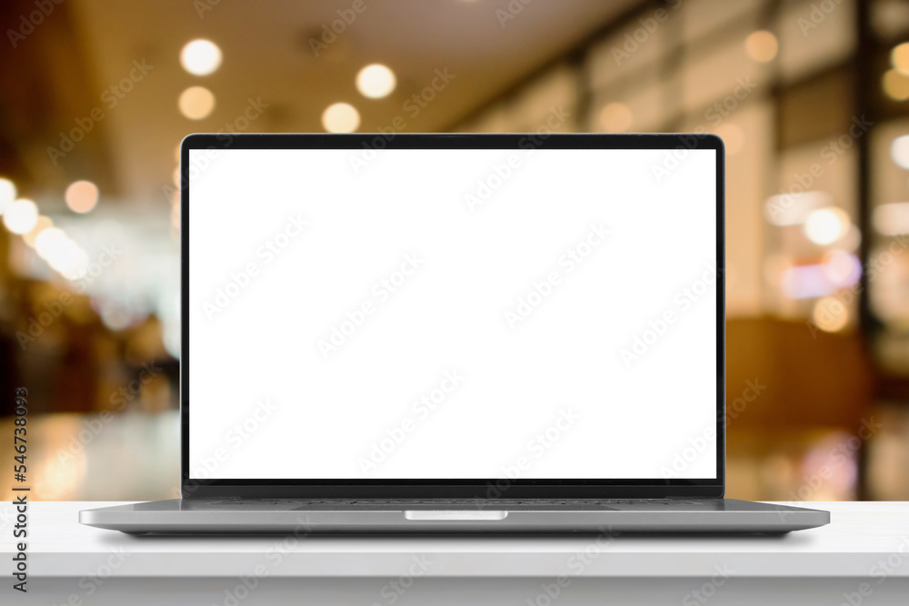 Laptop with blank screen on marble table with cafe coffee shop blur background Laptop with blank screen on marble table with cafe coffee shop blur background