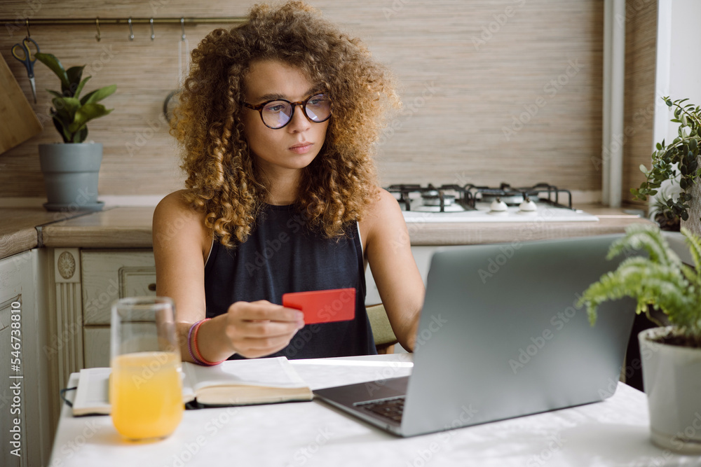 Young woman pays for online purchases on a laptop Young woman pays for online purchases on a laptop