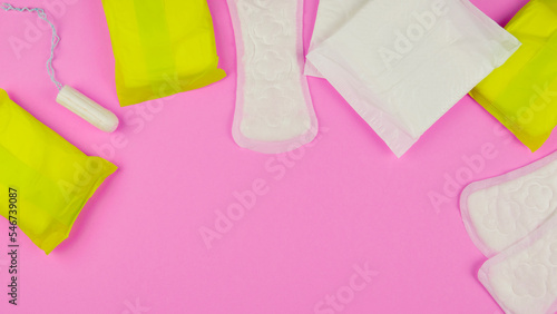 Hygiene products for women. Sanitary pads, tampon on a pink background. View from above