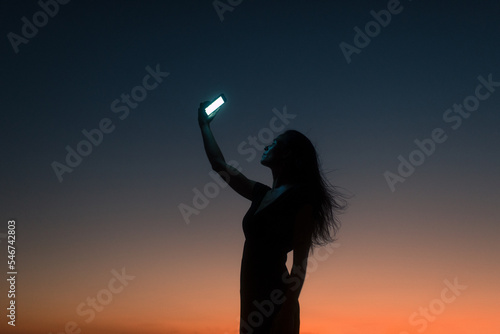 Surreal portrait of woman holding smartphone  photo