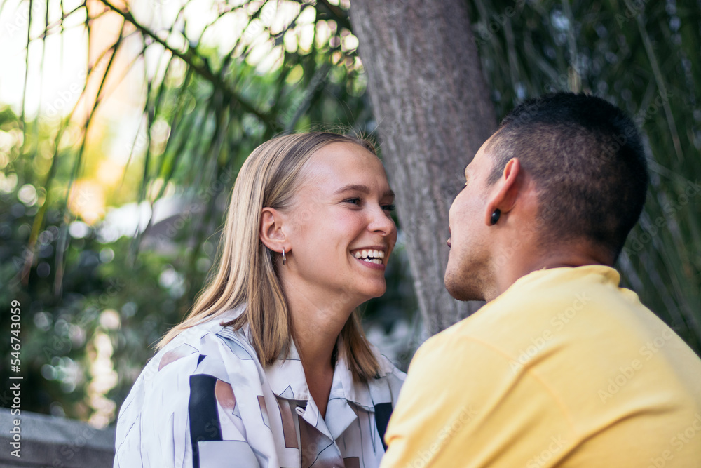 Multi-ethnic couple looking into each other's eyes outdoors Multi-ethnic couple looking into each other's eyes outdoors