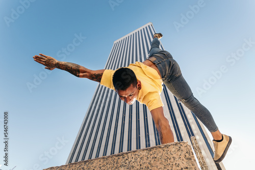 Gymnast doing a handstand in an urban area with skyscrapers