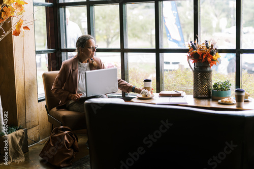 woman in business attire working at a cafe