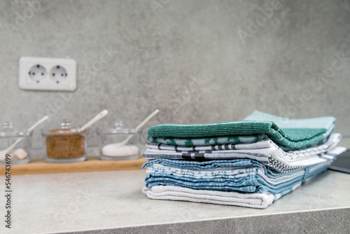 Kitchen towels in a pile on the kitchen table. Space for text.