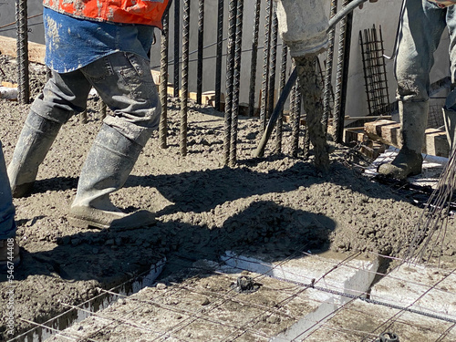 construction working men manipulating concrete pump