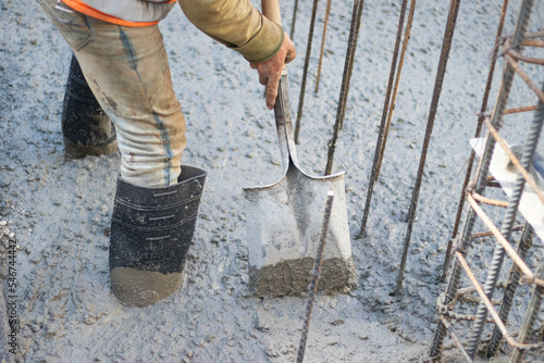 construction worker pouring pumped concrete with a shovel