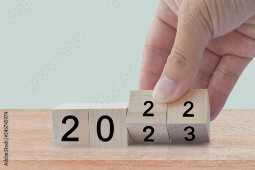 New year 2022 change to 2023. Hand flip over wooden cube block. New year holiday concept