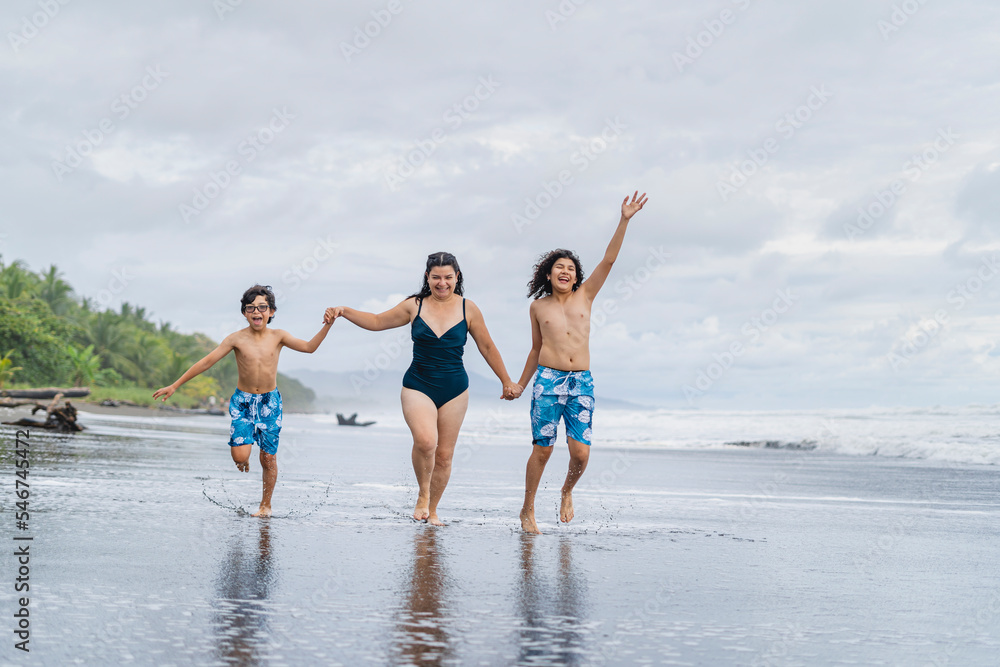 Mother and children running on the beach. Mother and children running on the beach.