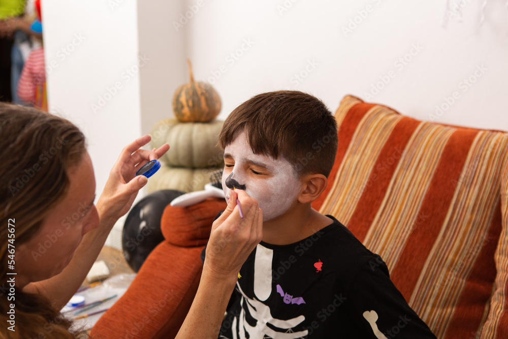 Little boy has halloween face paint applied Little boy has halloween face paint applied