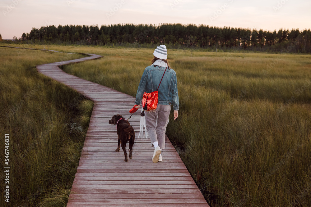 Unrecognizable young woman walking her dog Unrecognizable young woman walking her dog